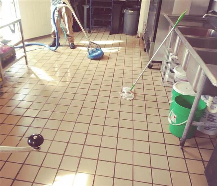 Guy cleaning restaurant kitchen floor after fire suppression went off  