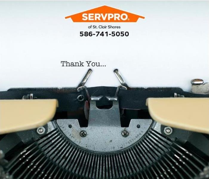A person has typed “thank you” on a typewriter.