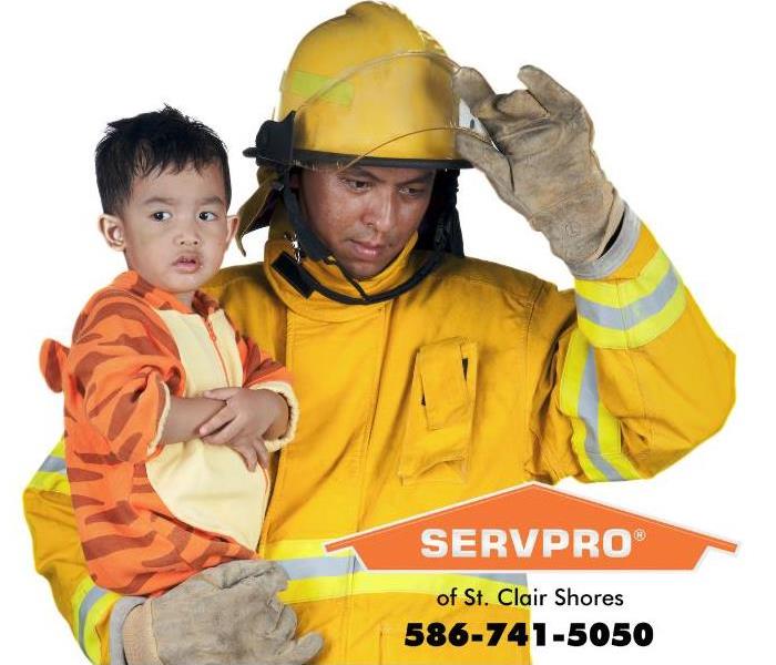 A firefighter is shown holding a small child. 