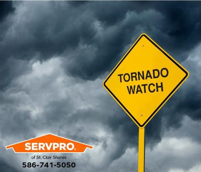A sign reading “tornado watch” is shown on a dark and stormy day.